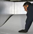 A contractor installing TerraBlock™ floor insulation in a Mount Vernon crawl space